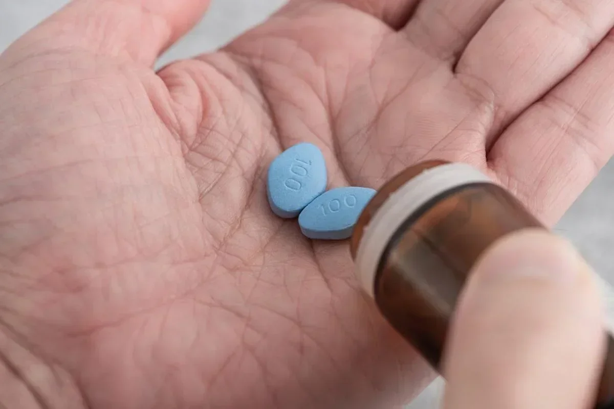 Pilules bleues versées dans une main