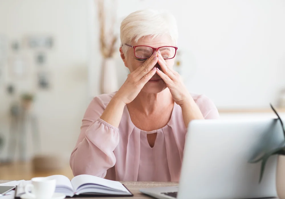 Ældre kvinde frustreret ved sin computer